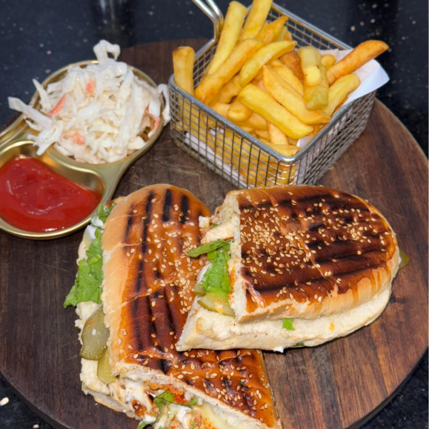 Spicy chicken sandwich from Bob's Diner, a highlight of intercontinental cuisine in Lagos, featuring crispy fried chicken, fresh lettuce, and a tangy sauce